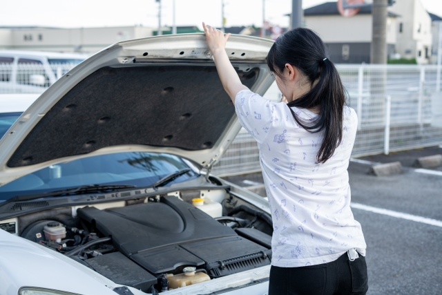 車のボンネットを開ける女性
