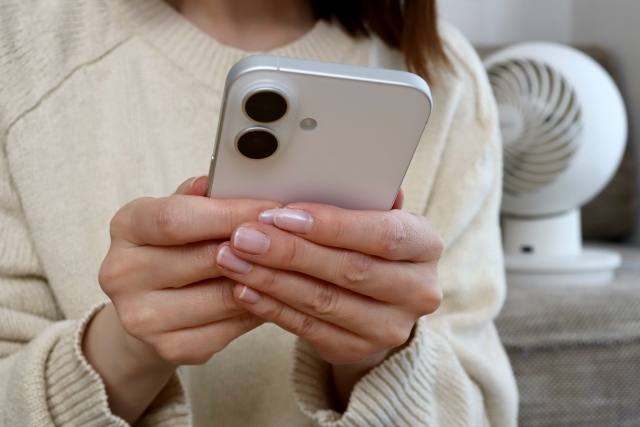 スマホを持つ女性の手