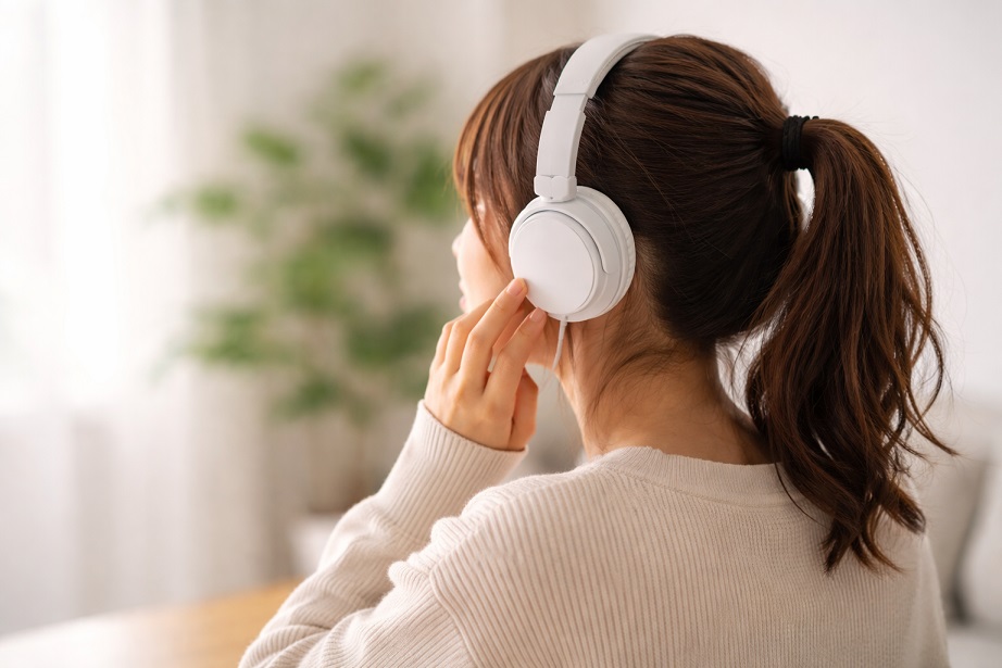 白いヘッドフォンをつけた女性